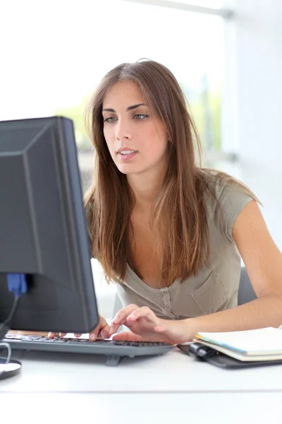 Jovem mulher trabalhando no computador desktop — Fotografia de Stock