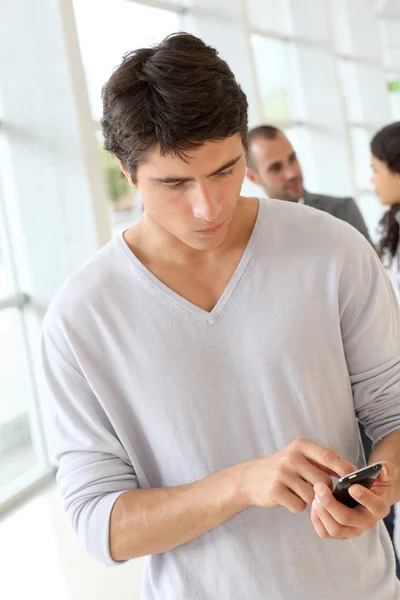 Estudiante enviando mensaje con teléfono móvil — Foto de Stock