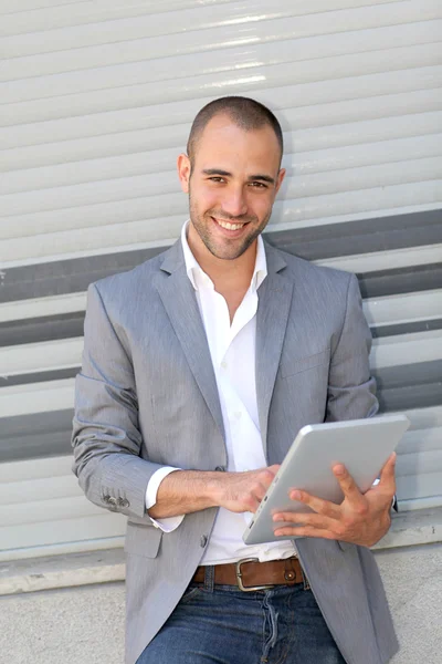 Homem inclinado na parede com tablet eletrônico — Fotografia de Stock