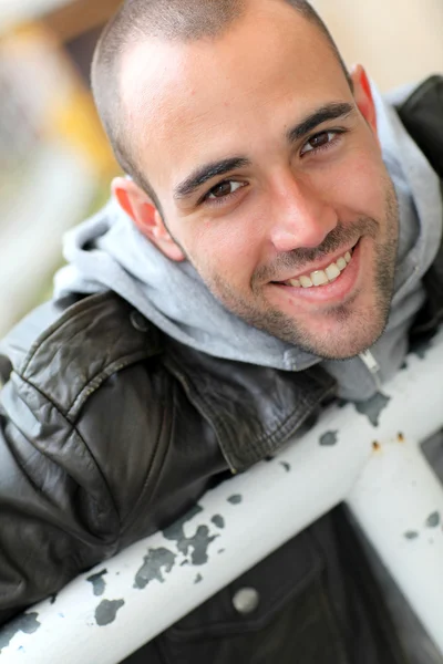 Lächelnder junger Mann mit Lederjacke in der Stadt — Stockfoto