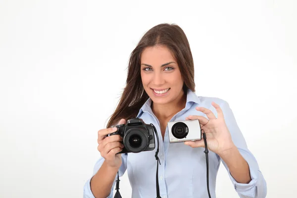 Junge Frau vergleicht digitale Kompakt- und Spiegelreflexkameras — Stockfoto