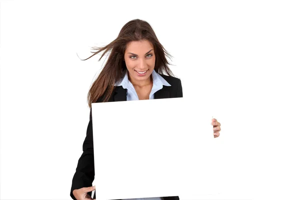 Mujer de negocios sonriente sosteniendo pizarra — Foto de Stock