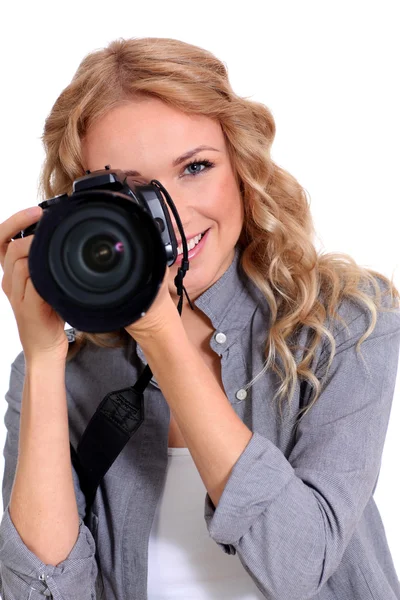 Mujer usando cámara fotográfica en estudio Imagen de archivo