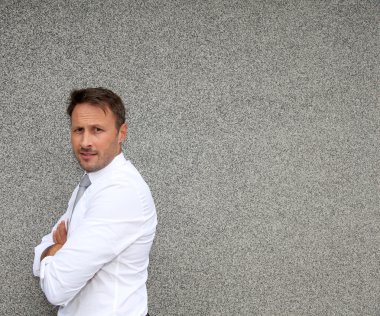 Beton duvara karşı duran işadamı