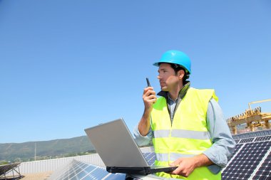 Engineer checking photovoltaic installation clipart