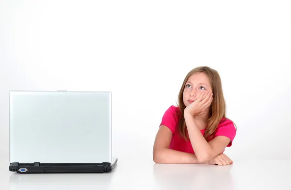 Menina com olhar pensativo ao lado do computador portátil — Fotografia de Stock