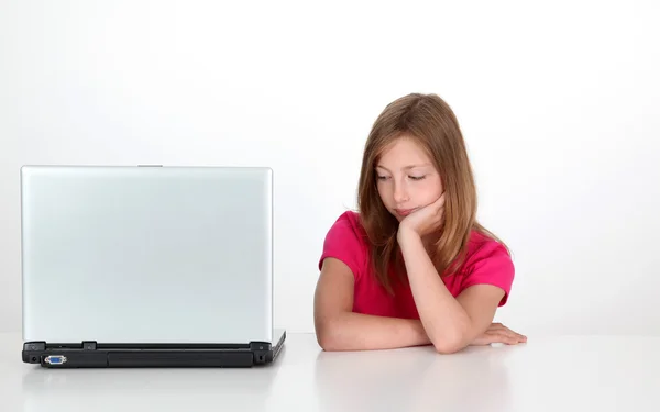 Ragazza con sguardo premuroso accanto al computer portatile — Foto Stock