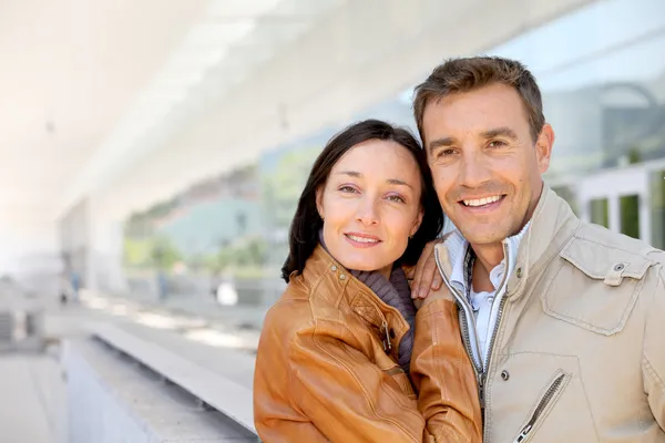 Couple souriant debout devant l'aéroport — Photo