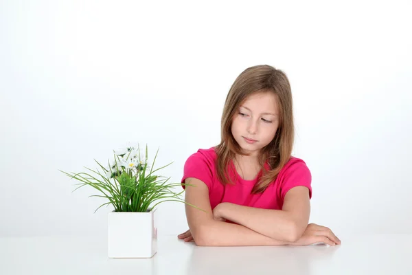 Портрет молодой девушки, смотрящей на растение — стоковое фото