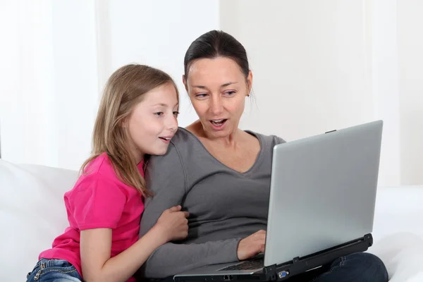 Madre e hija usando computadora portátil en casa —  Fotos de Stock