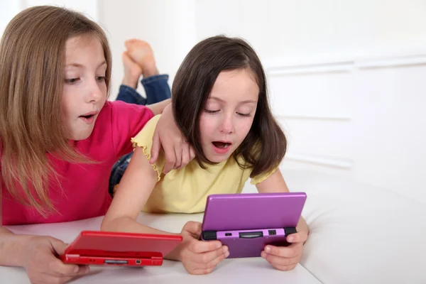 Chicas jóvenes jugando con la consola de juegos en el sofá —  Fotos de Stock