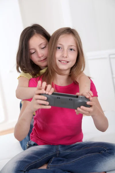 Chicas jóvenes jugando con la consola de juegos en el sofá —  Fotos de Stock