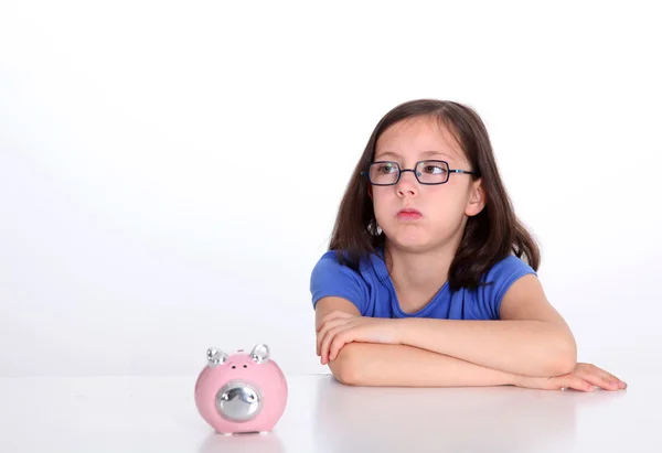 Menina com olhar entediado sentado por piggybank — Fotografia de Stock