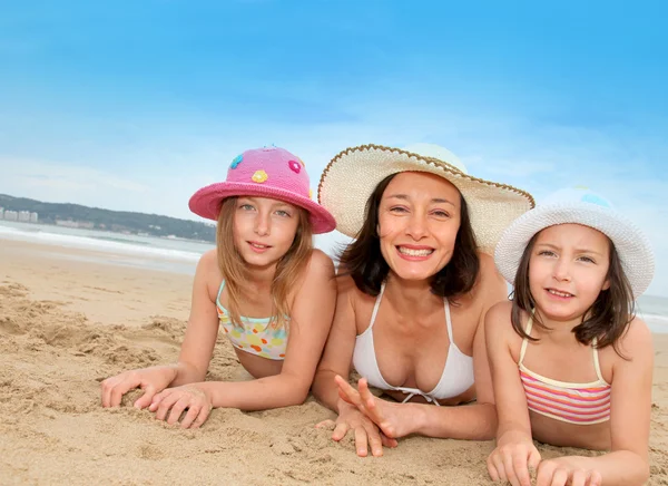 Mãe e filhas deitadas na praia — Fotografia de Stock