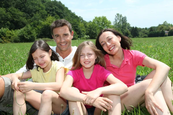 Happy family sitting in park — Stock Photo, Image