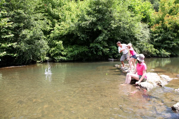 Family playing ricochet in river — Stock Photo, Image