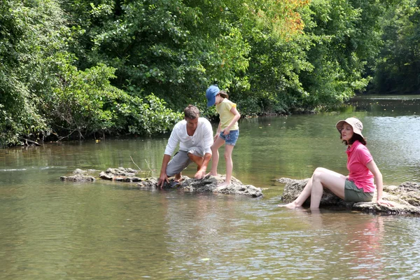 Семья, сидящая в реке летом — стоковое фото