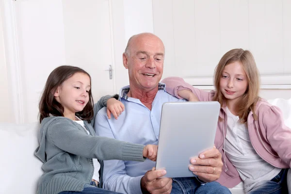 Grand-père avec des enfants utilisant une tablette électronique — Photo