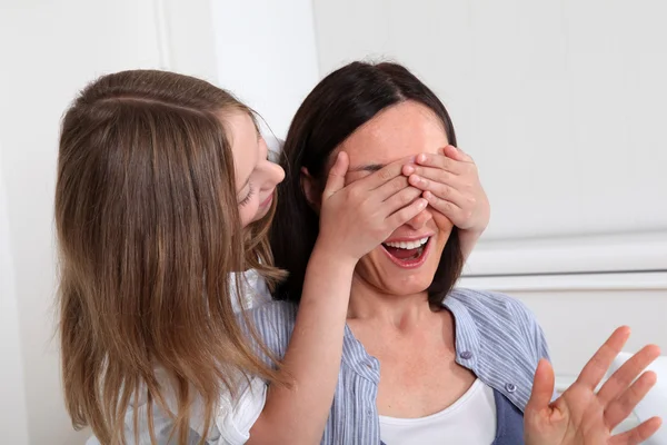 Girl hiding her mother eyes — Stock Photo, Image