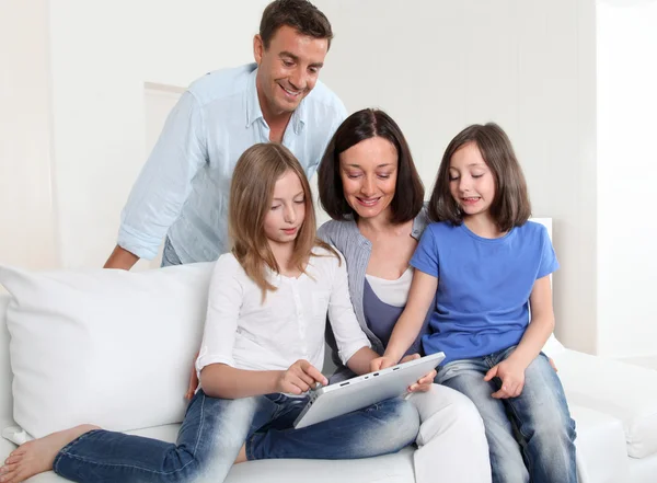 Padres e hijos usando tableta electrónica en casa — Foto de Stock