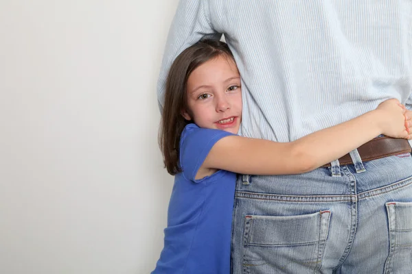 Niña poniendo brazos alrededor de la cintura de su padre — Foto de Stock