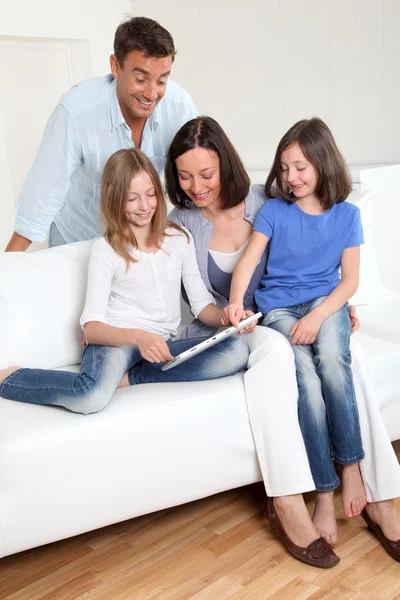 Γονείς και παιδιά που χρησιμοποιούν ηλεκτρονικό, ταμπλετών στο σπίτι — Φωτογραφία Αρχείου