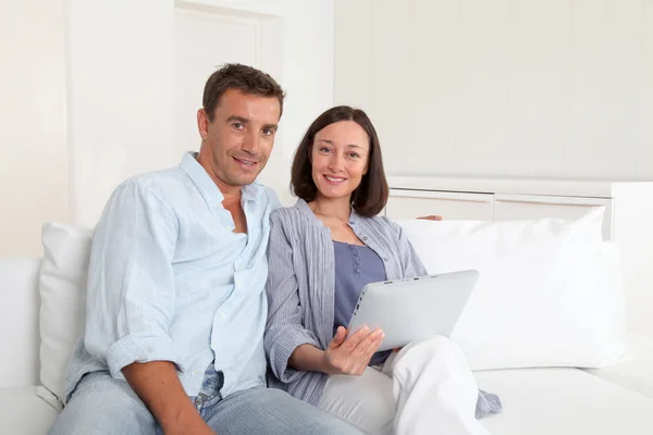 Par i soffa med elektroniska tablett — Stockfoto