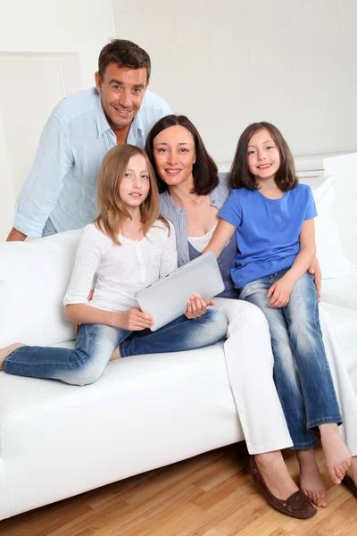 Parents et enfants utilisant une tablette électronique à la maison — Photo