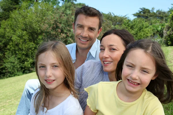 Porträtt av familj sitter i parken — Stockfoto