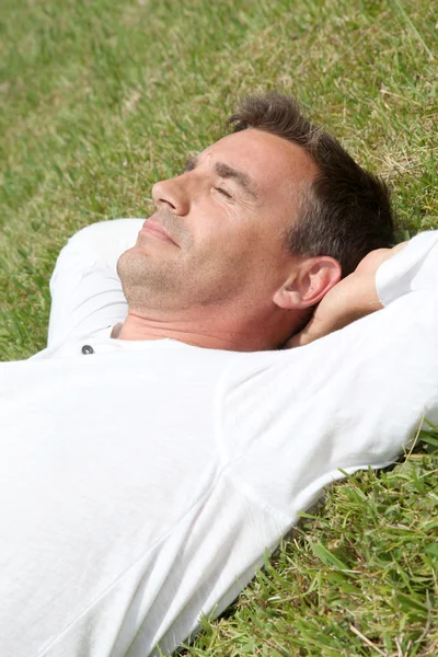 Homem deitado no parque — Fotografia de Stock