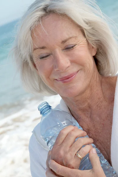 Donna anziana che beve acqua dalla bottiglia — Foto Stock