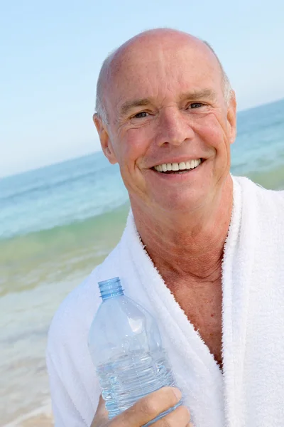 Портрет улыбающегося пожилого человека с бутылкой воды — стоковое фото