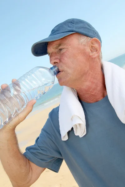 Portrait of athletic senior man drinking water — Stock Photo, Image