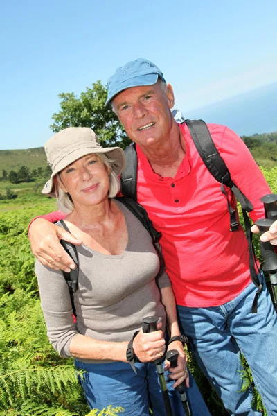 Portret van gelukkige senior paar wandelen in natuurlijke landschap — Stockfoto