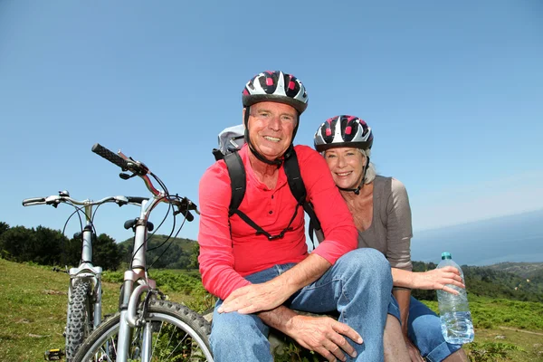 Senior koppel rijden mountainbikes in natuurlijke landschap — Stockfoto