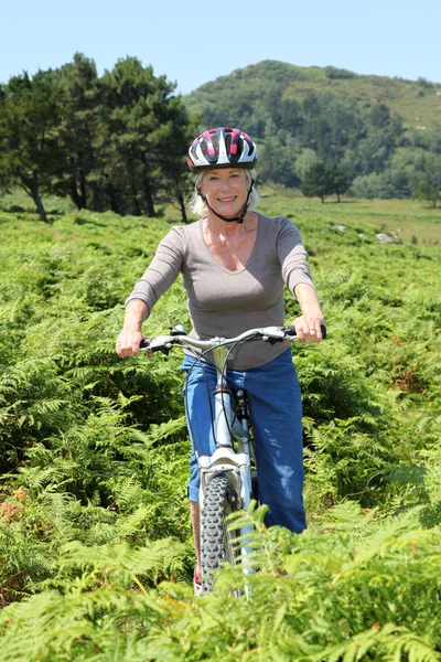 Senior mulher andar de bicicleta de montanha — Fotografia de Stock