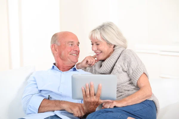 Старша пара використовує електронний планшет вдома — стокове фото