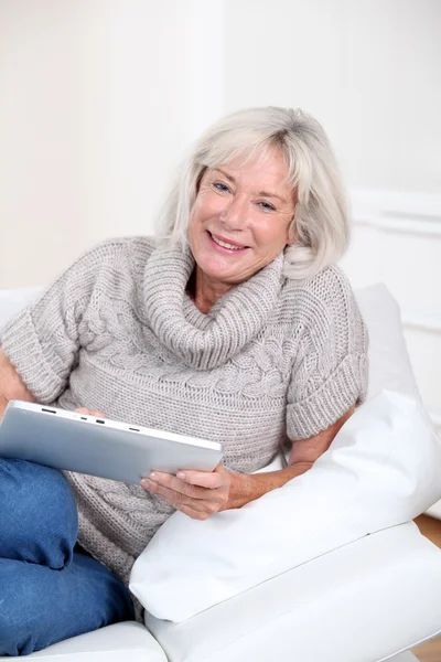 Seniorin benutzt zu Hause elektronisches Tablet — Stockfoto