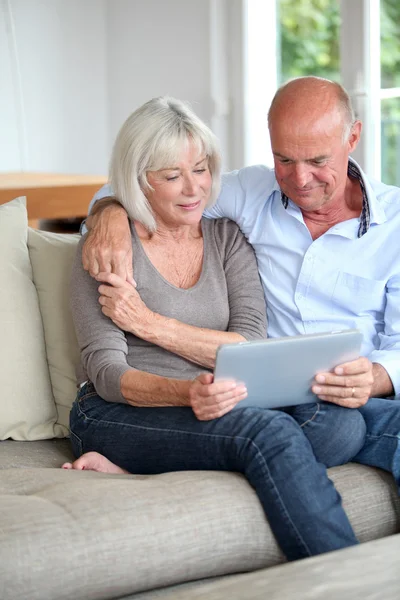 Старша пара використовує електронний планшет вдома — стокове фото