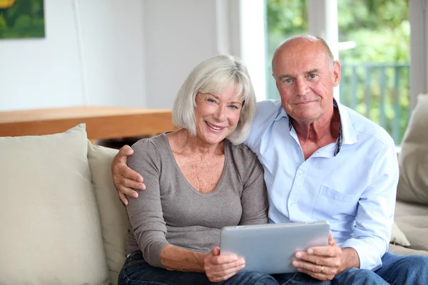 Couple de personnes âgées utilisant une tablette électronique à la maison — Photo