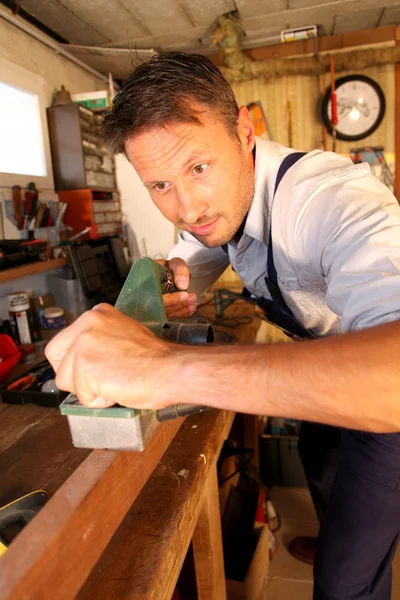 Столяр, обрабатывающий древесину в мастерской — стоковое фото