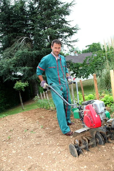 Jardineiro usando cultivador motorizado — Fotografia de Stock