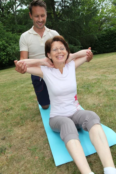 Allenamento allenatore sportivo donna anziana con esercizi di stretching — Foto Stock