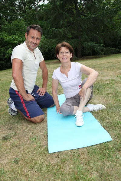 Allenamento allenatore sportivo donna anziana con esercizi di stretching — Foto Stock