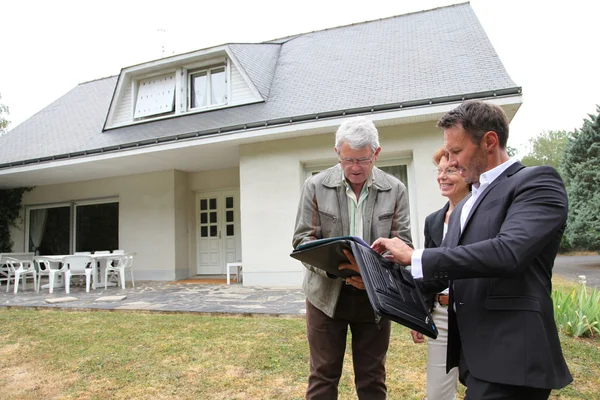 Агент по недвижимости с пожилой парой, покупающей новый дом — стоковое фото