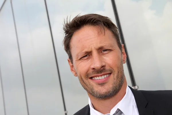 Portrait of businessman standing in front of modern building — Stock Photo, Image