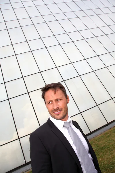 Portrait of businessman standing in front of modern building — Stock Photo, Image