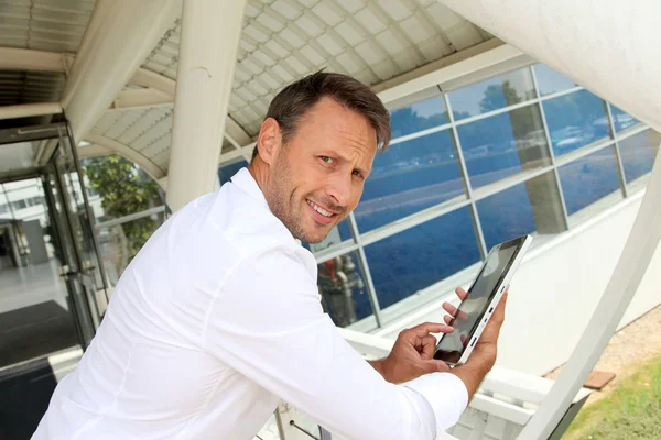 Empresário usando tablet eletrônico fora do aeroporto — Fotografia de Stock