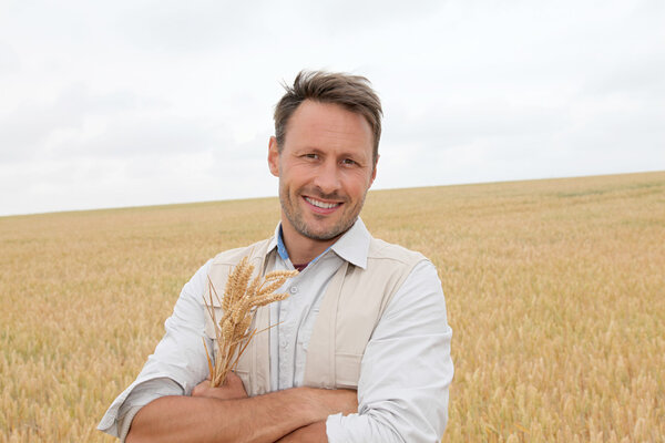 Portrait of handsome man standing in wheat field