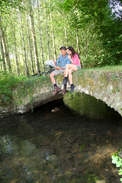 Coppia seduta su un ponte nella foresta — Foto Stock